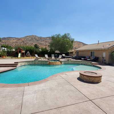 Backyard pool with a stone fire pit in Moreno Valley